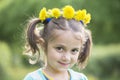 Portrait of a girl with a wreath of dandelions.