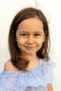 Portrait of a girl of 7 years old with brown hair and brown eyes in a gentle blue romantic blouse on a white background