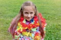 Portrait of a girl of 9 years old sits and smiles on a sunny day. Spring Girl. Hawaiian garlands Royalty Free Stock Photo