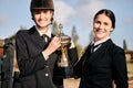 Portrait, girls and champion for equestrian, competition and horse riding with trophy at ranch. Young, women and
