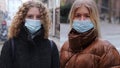 Portrait of 2 girls who wear a surgical mask outdoor to protect themself from the coronavirus pandemic