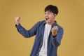 Portrait of glad cheerful happy rejoicing excited overjoyed young asian man dressed casually isolated on yellow background