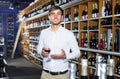 Portrait of glad male customer tasting wine before purchasing it