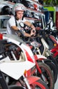 Portrait of glad male in helmet on motorbike in the store