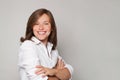 Portrait of glad smiling happy doctor in white coat uniform standing with crossed hands on grey wall background Royalty Free Stock Photo