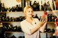 Portrait of glad woman choosing glazed with red color ceramic ut