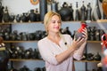 Portrait of glad woman choosing glazed with red color ceramic ut Royalty Free Stock Photo