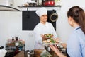 Man cook giving to waitress ready to serve salad Royalty Free Stock Photo