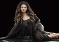 Portrait of a glamorous brunette female wearing a boho laced draped clothing while relaxing under studio lighting. Royalty Free Stock Photo