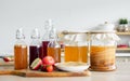 Portrait glass bottles of Kombucha healthy fermented probiotic tea drinks with ingredients red apples, strawberries, mushroom