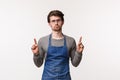 Portrait of gloomy and indifferent young bored guy working coffee shop or restaurant over bar counter, wear apron Royalty Free Stock Photo