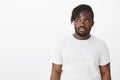 Portrait of gloomy unhappy dark-skinned plump boyfriend in white t-shirt, gazing left with uninterested indifferent