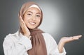 Portrait of glowing beautiful muslim woman isolated against grey studio background. Young woman wearing a hijab or Royalty Free Stock Photo