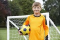 Portrait Of Goal Keeper Holding Ball On School Soccer Pitch