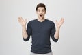 Portrait of good-looking male model expressing surprise and joy raising his hands, isolated over white background. Man Royalty Free Stock Photo