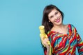 Portrait of a smiling young woman with a vintage yellow video camera in her hands posing against a blue background