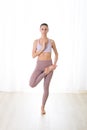 Portrait of gorgeous active sporty young woman practicing yoga in studio. Beautiful girl practice Tadasana, tree yoga Royalty Free Stock Photo