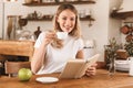 Portrait of gorgeous blond woman reading book and drinking coffee while sitting in cozy cafe indoor Royalty Free Stock Photo