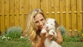 PORTRAIT: Gorgeous blonde girl playing in the backyard with her adorable puppy. Royalty Free Stock Photo