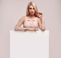 Gorgeous blonde woman holding a blank billboard Royalty Free Stock Photo