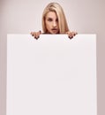 Gorgeous blonde woman holding a blank billboard Royalty Free Stock Photo