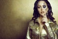 Portrait of gorgeous dark-haired model with artistic creative clock make up wearing golden leather jacket Royalty Free Stock Photo