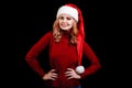 Beautiful happy festive girl in a santa cap on a black background. Christmas costume concept. Royalty Free Stock Photo