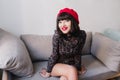 Portrait of gorgeous girl with short dark hair, sitting on the gray sofa and smiling seductive. Attractive young Royalty Free Stock Photo