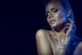 Portrait of gorgeous glam blond woman with wet hair, artistic glittering make-up and naked shoulders touching her neck