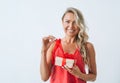 Portrait of gorgeous happy blonde young woman in red with gift box in hands on white background Royalty Free Stock Photo