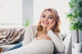 Portrait of gorgeous person sit sofa look away fantasize comfy domestic atmosphere apartment indoors