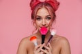 Portrait of gorgeous shirtless woman holding makeup brushes