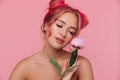 Portrait of gorgeous shirtless young woman holding peony flower