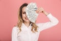 Portrait of gorgeous woman smiling and holding money fan isolated over pink background Royalty Free Stock Photo