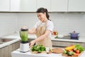 Portrait of a gorgeous young asian making some healthy juice for breakfast