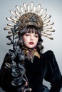 Portrait of a gorgeous young girl with beautiful makeup in an elegant headdress, golden crown.The face of a queen with long, black Royalty Free Stock Photo