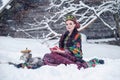 Portrait of a gorgeous young woman in russian style dress on a strong frost in a winter snowy day with apples and samovar.