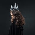 Portrait of a Gothic Princess. Beautiful young brunette woman in metal crown and black cloak. Royalty Free Stock Photo