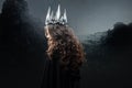 Portrait of a Gothic Princess. Beautiful young brunette woman in metal crown and black cloak. Royalty Free Stock Photo