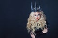 Portrait of a Gothic Queen. Beautiful young blonde woman in metal crown and black cloak. Royalty Free Stock Photo