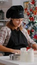 Portrait of grandchild wearing apron rolling homemade dough using rooling pin