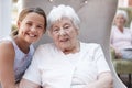 Portrait Of Granddaughter Visiting Grandmother In Retirement Home