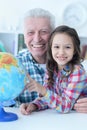 Portrait of grandfather and granddaughter exploring world globe