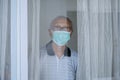 Grandfather looking through the window with mask
