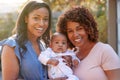 Portrait Of Grandmother With Adult Daughter And Baby Granddaughter In Garden At Home Together