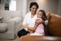 Portrait of grandmother and granddaughter embracing on sofa at home Royalty Free Stock Photo