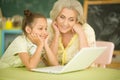 Portrait of grandmother and granddaughter using laptop