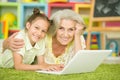 Portrait of grandmother and granddaughter using laptop