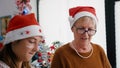 Portrait of grandmother with granddaughter wearing santa hats