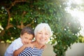 Portrait, grandmother and piggyback child in garden or bonding, together or quality time in backyard or fun on summer